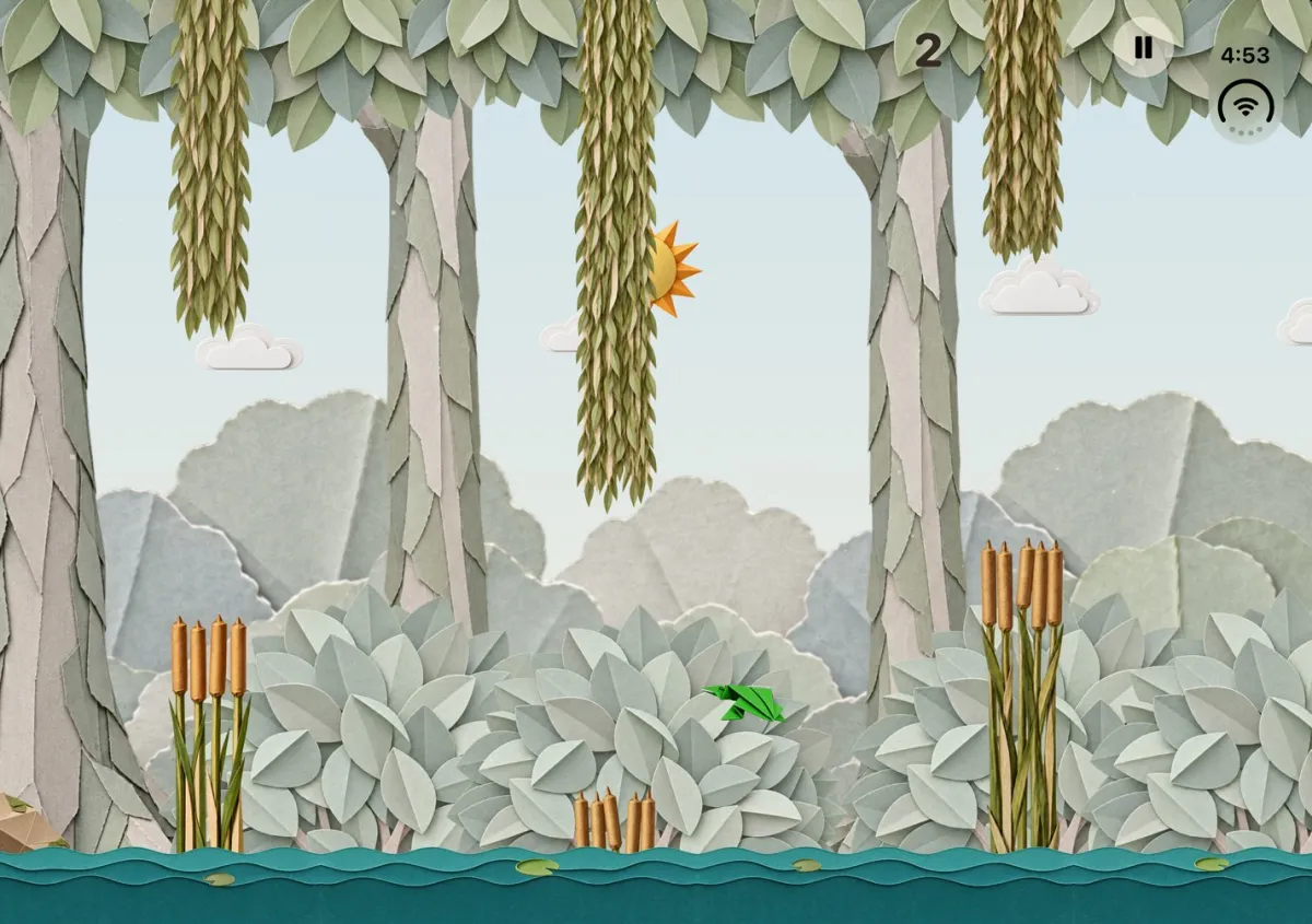 Lily Pond on the iPhone Duo inner display: a green origami frog flies between hanging paper willow branches, over a pond with cattails and paper trees.